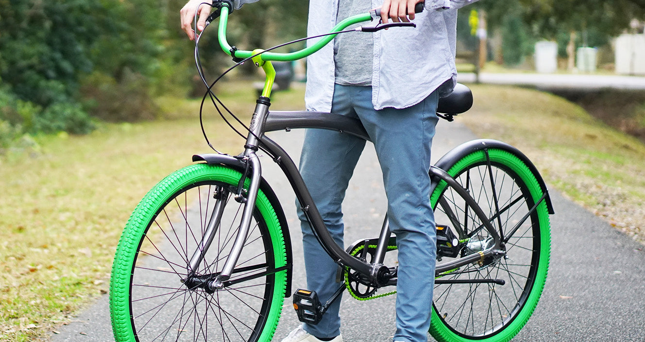 A guy with his matte grey and green Villy bike at the park